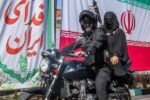 یک تصویر متفاوت/ بانوی مسلح روی موتور در میادین تهران + عکس